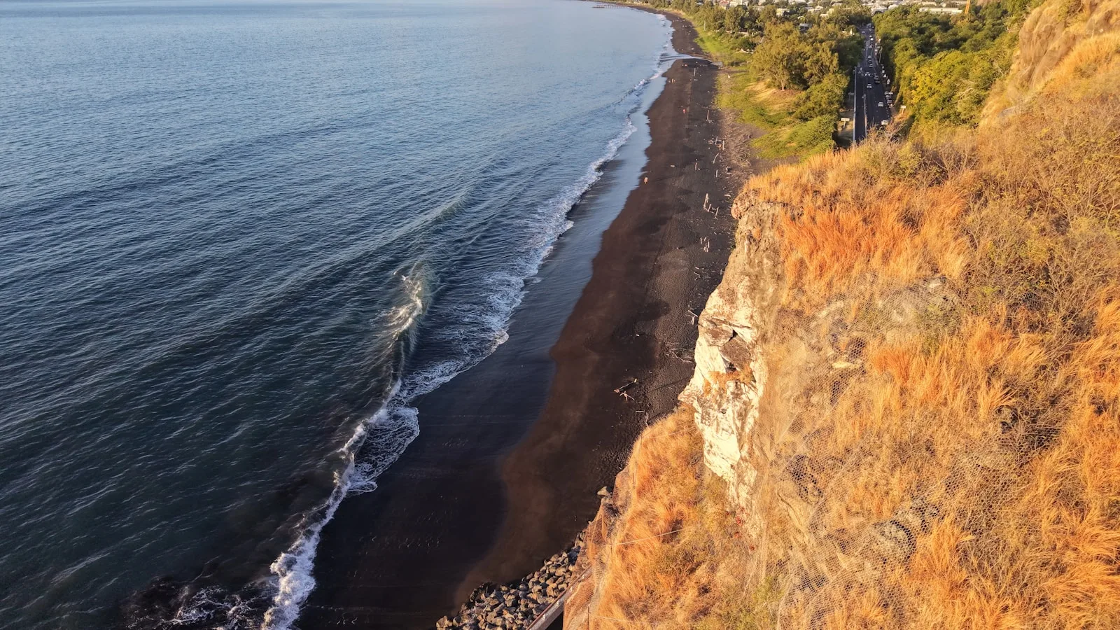 Parent avec bébé en poussette sur le front de mer de La Réunion